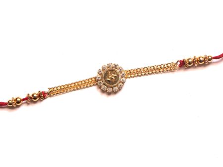 Gold finish swastik rakhi with white crystals For Discount