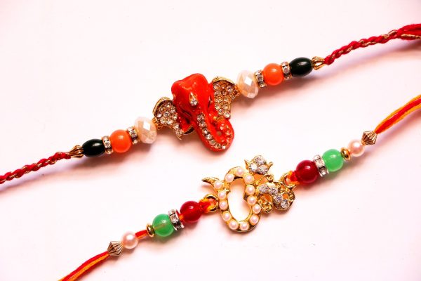 Combo rakhi pack of orange Ganesha and pearl Om Discount